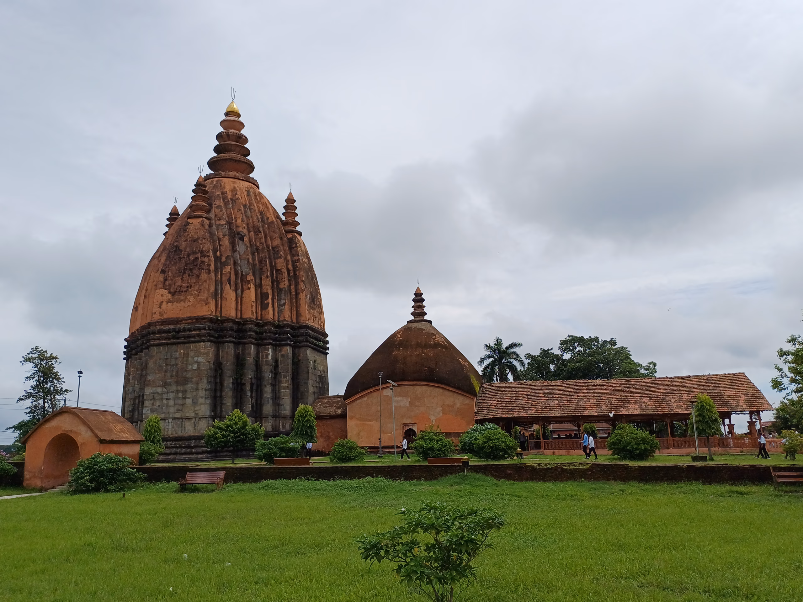 The towering Sivadol temple shikhara rising above its terrace beside the Sivasagar tank, with adjoining domed shrine and prayer hall